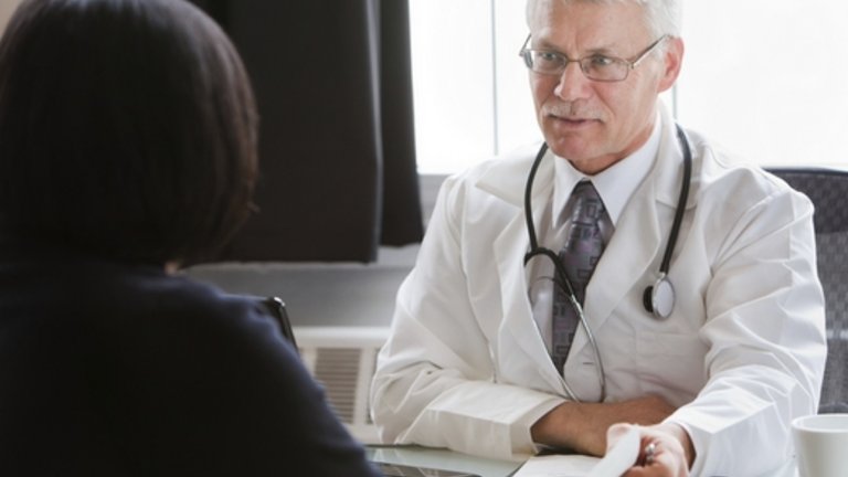 Männlicher Arzt spricht mit einem Patienten